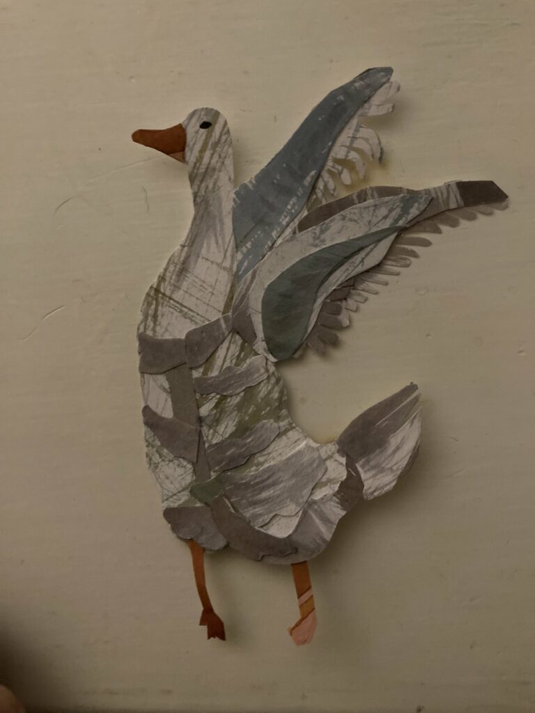 goose swatting his wings with them up in the back made of cut paper