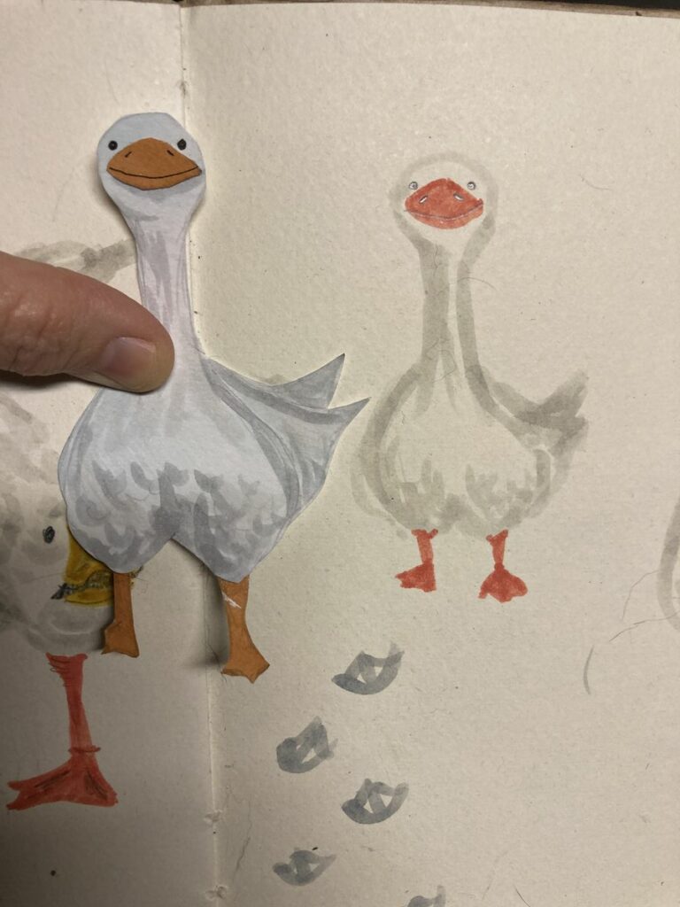 goose illustration out of cut paper next to the original drawing
