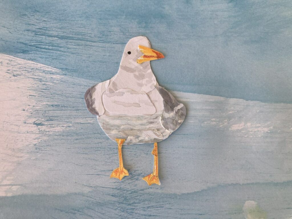 seagull out of cut paper on a blue background